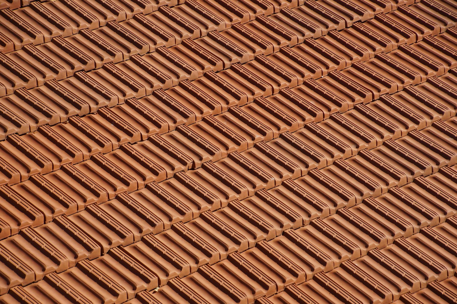Zbliżenie na zachodzące na siebie czerwone dachówki ceramiczne