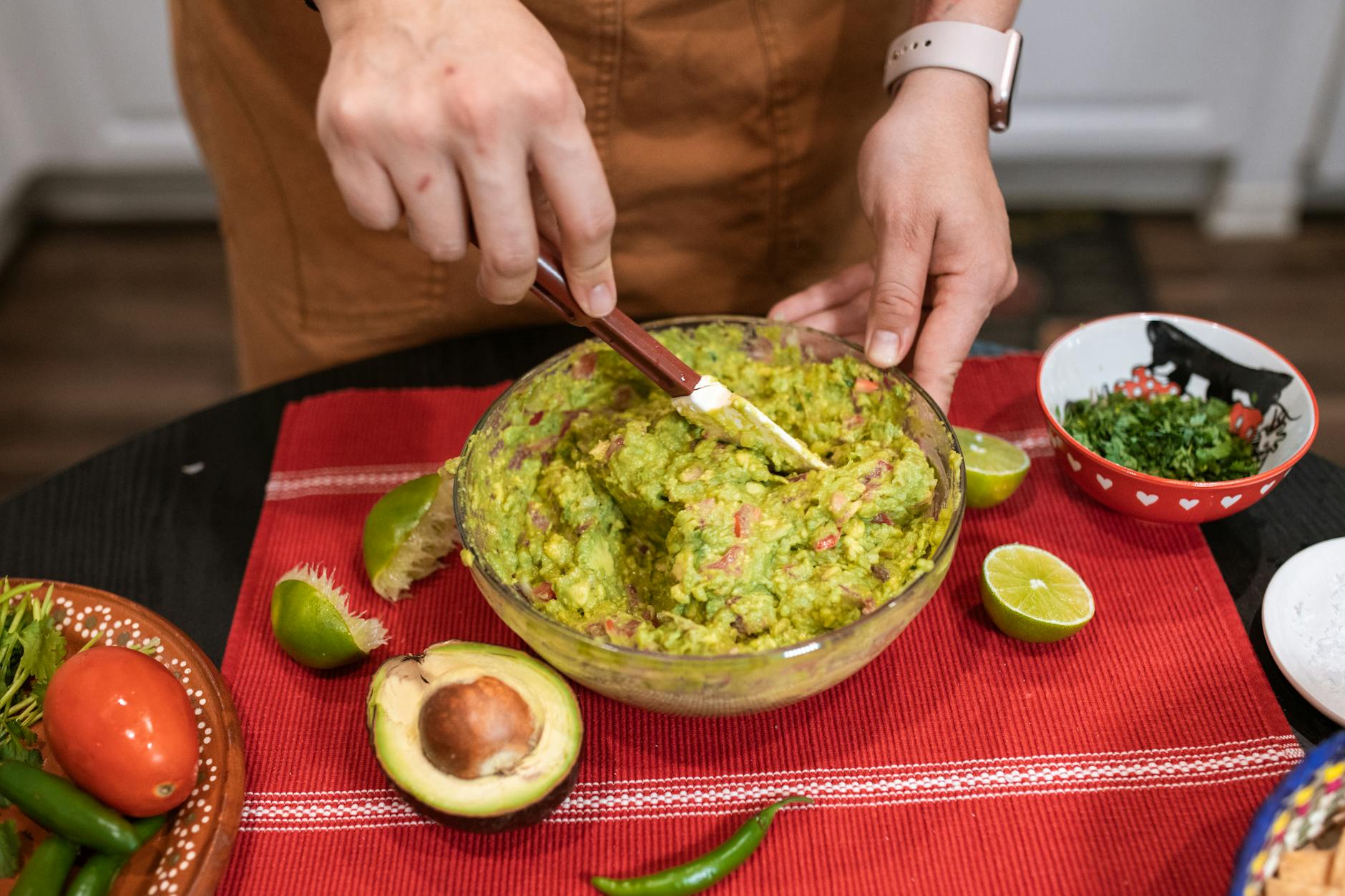 Dłonie mieszają domowe guacamole z kolendrą w kuchni