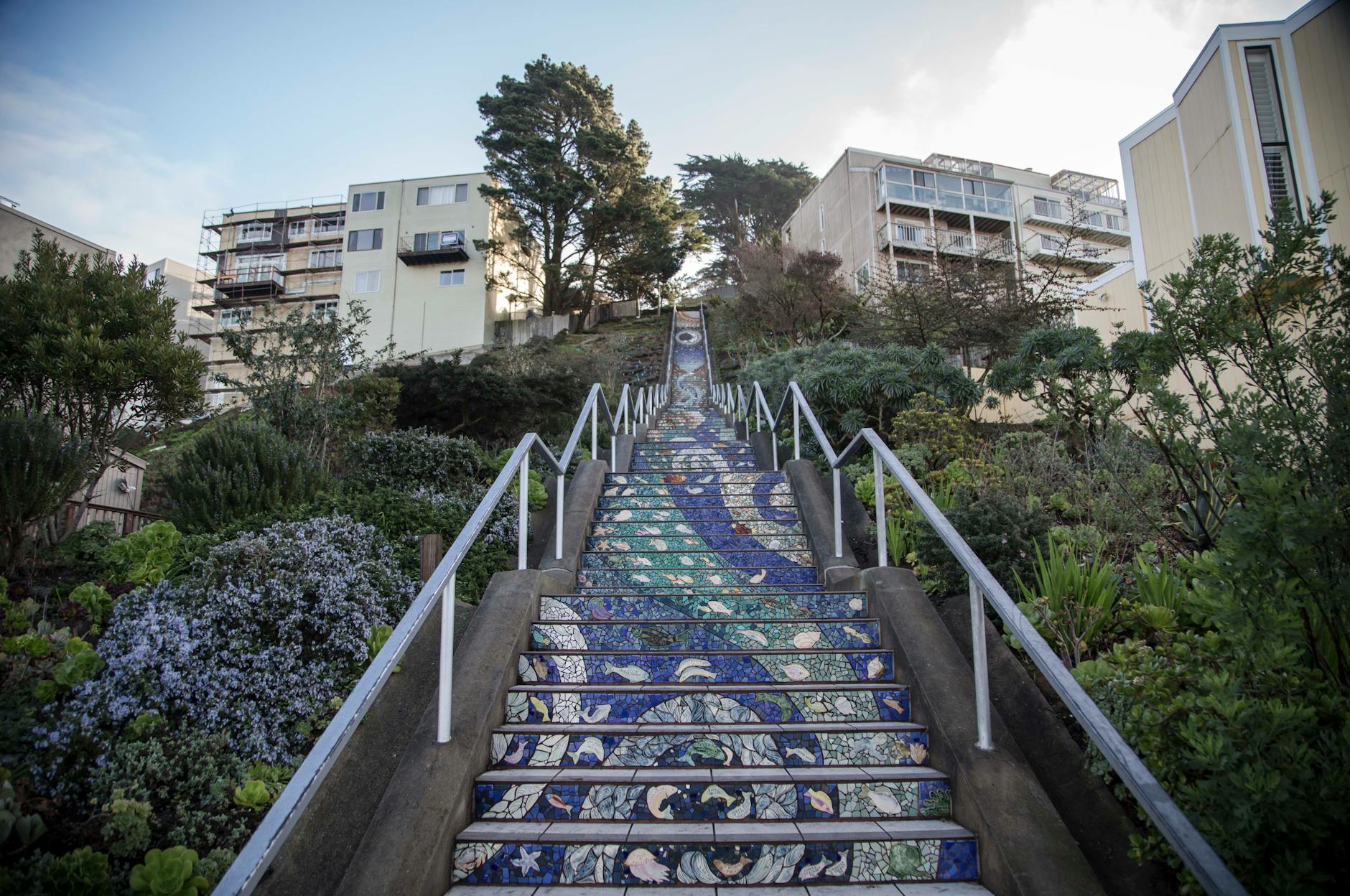 Montaż płytek na schodach: noski, antypoślizg i trwałe krawędzie Schody z mozaikowych płytek między budynkami, widok z dołu