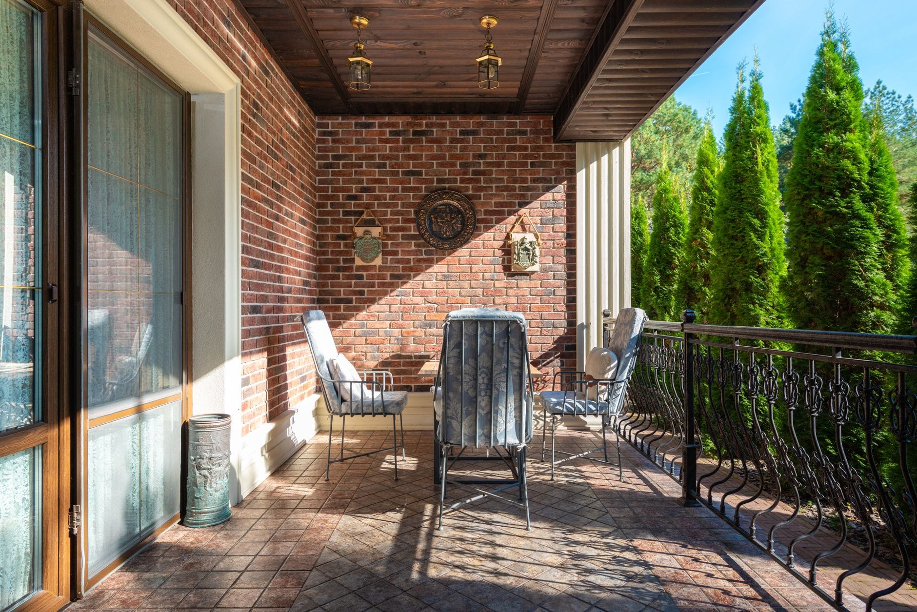 Przytulny balkon z gresową podłogą, krzesłami i ceglaną ścianą