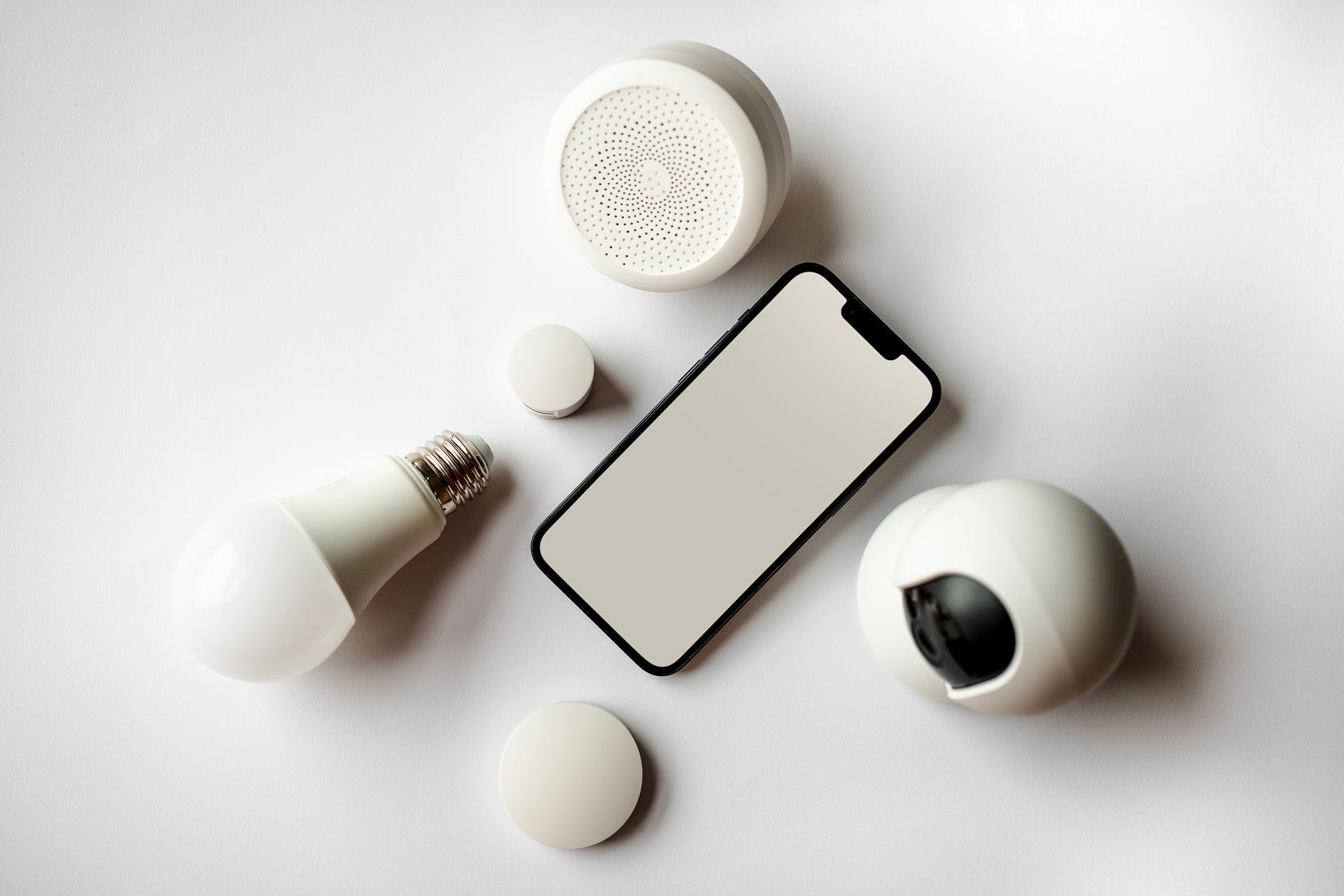 Smartfon i akcesoria smart home rozłożone na białym tle