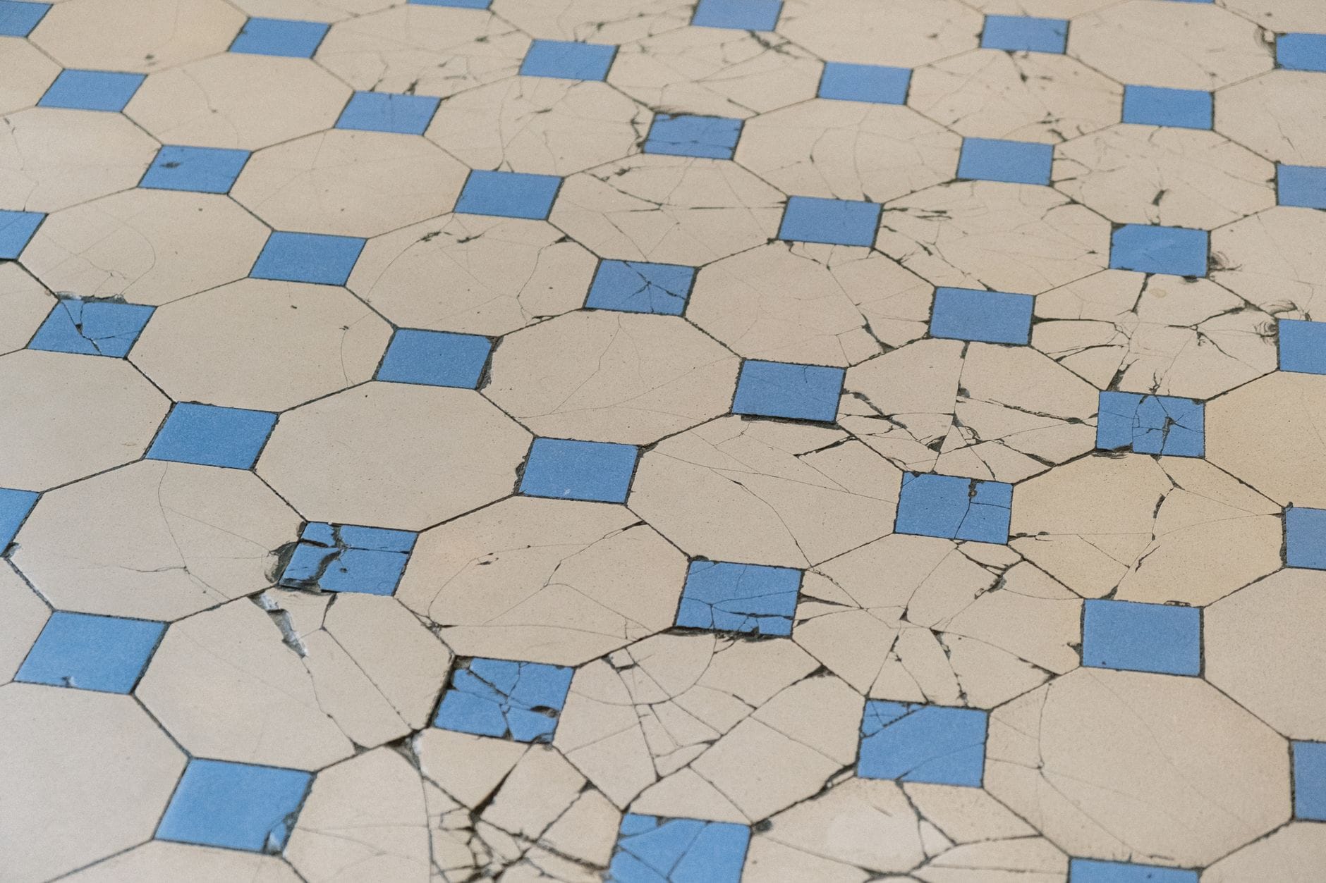 Spękane stare płytki w niebiesko-biały wzór geometryczny