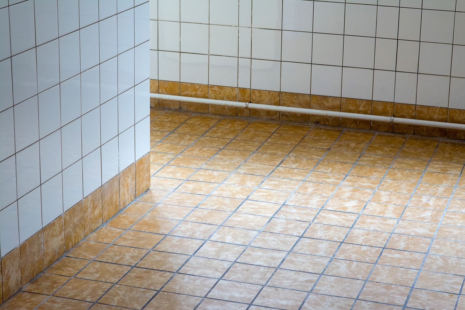 Minimalistyczne, puste wnętrze z podłogą i ścianami z płytek gresowych